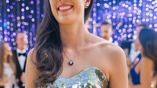 model wearing Na Hoku Horizon jewelry and gold glitter dress at party; other guests in background talking