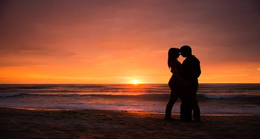 Couple hugging at beach upon sunset